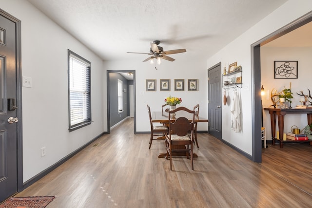 dining space with hardwood / wood-style floors, a textured ceiling, and ceiling fan