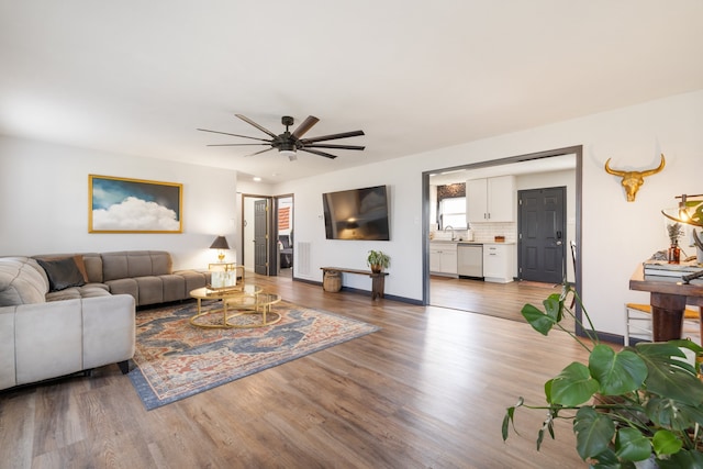 living room with sink, dark wood-type flooring, and ceiling fan