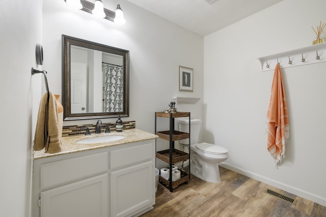 bathroom featuring vanity, toilet, and hardwood / wood-style flooring