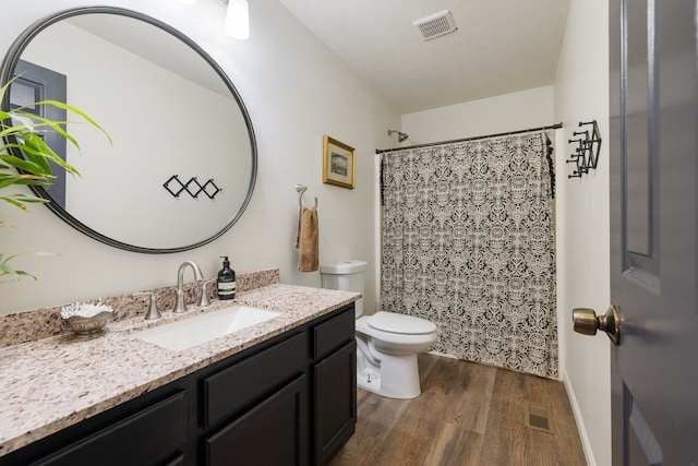 bathroom featuring vanity, toilet, walk in shower, and hardwood / wood-style floors