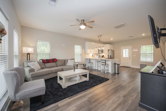 living room featuring ceiling fan, hardwood / wood-style flooring, and a wealth of natural light