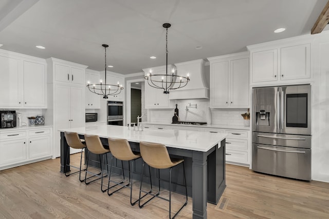 kitchen featuring appliances with stainless steel finishes, white cabinetry, and light hardwood / wood-style floors