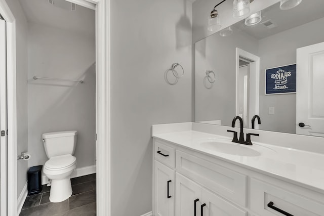 bathroom featuring toilet, vanity, and tile patterned flooring