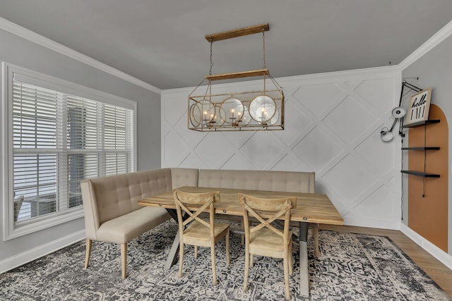 dining space featuring a notable chandelier, ornamental molding, and hardwood / wood-style flooring