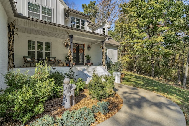 property entrance with french doors, cooling unit, and a lawn