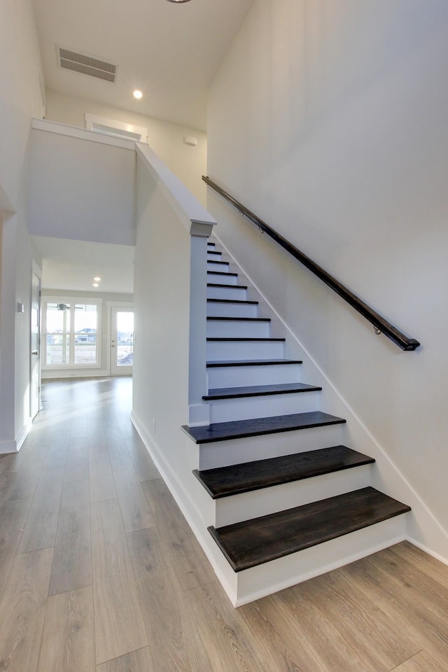 staircase featuring hardwood / wood-style floors and a high ceiling