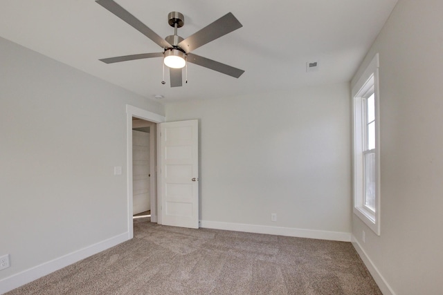 carpeted spare room with ceiling fan