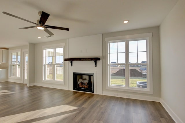 unfurnished living room featuring ceiling fan, a healthy amount of sunlight, and hardwood / wood-style flooring