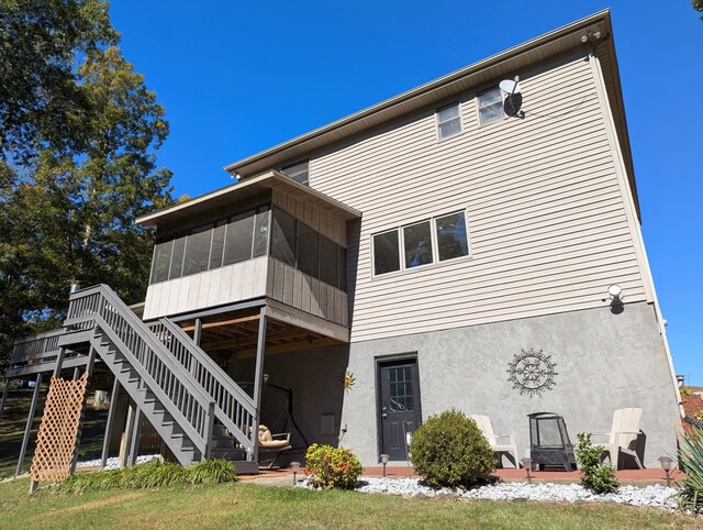 rear view of house with a sunroom and a deck