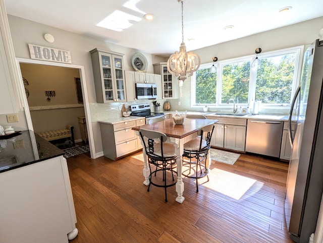 kitchen featuring pendant lighting, stainless steel appliances, dark hardwood / wood-style floors, and sink