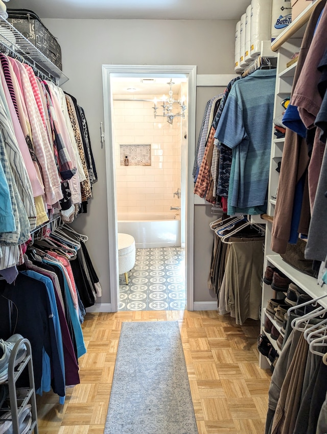 walk in closet with light parquet flooring