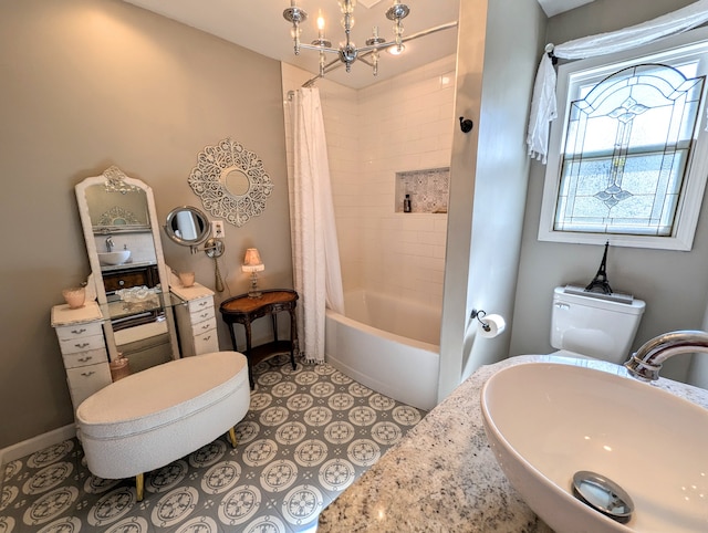 full bathroom featuring toilet, a chandelier, shower / tub combo with curtain, and sink