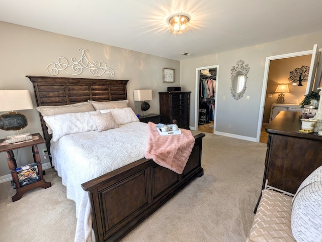 carpeted bedroom with a walk in closet and a closet