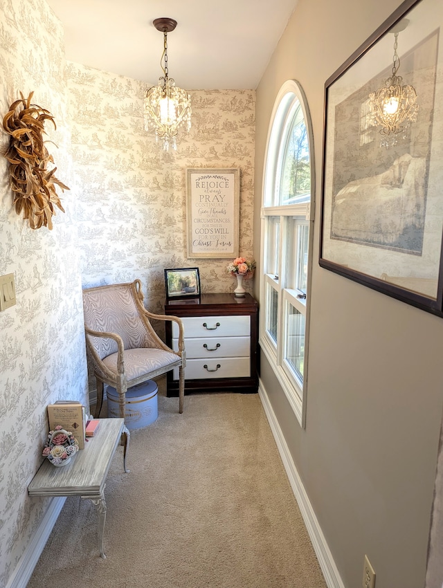 living area with carpet and an inviting chandelier