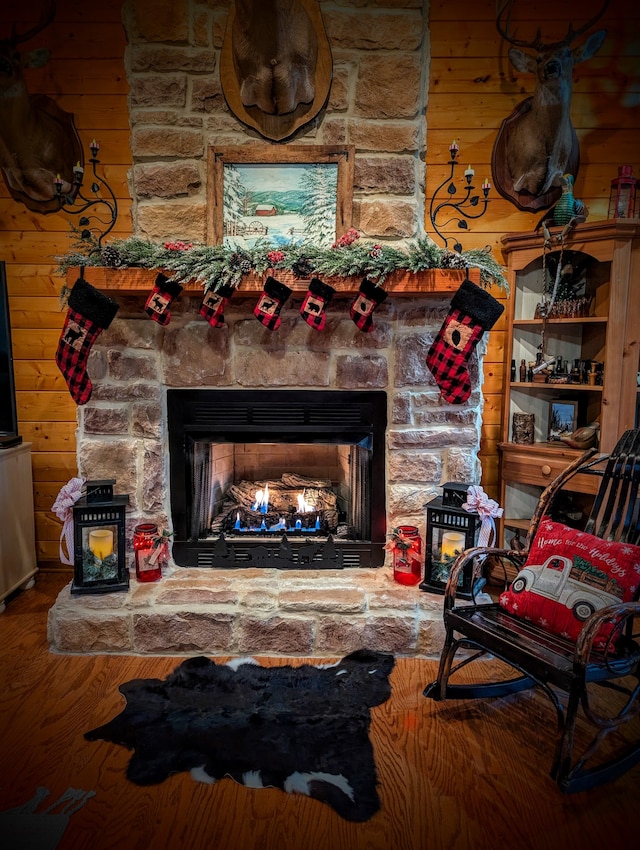 room details featuring a stone fireplace and wood-type flooring