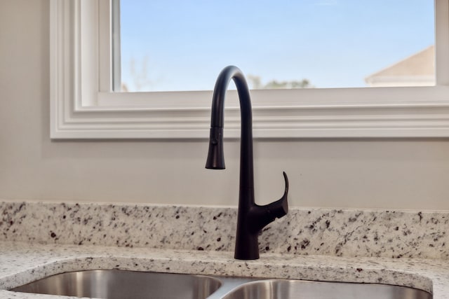 room details featuring light stone countertops and sink