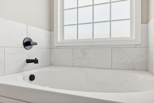 bathroom featuring plenty of natural light and a bath