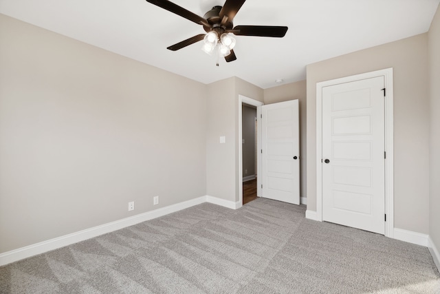 unfurnished bedroom featuring ceiling fan, a closet, and light colored carpet