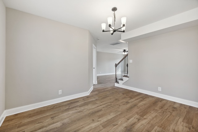 unfurnished dining area with wood-type flooring and ceiling fan with notable chandelier