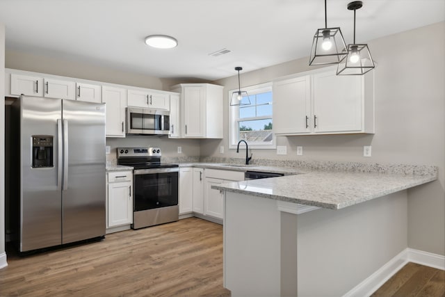 kitchen with stainless steel appliances, white cabinetry, hanging light fixtures, and sink