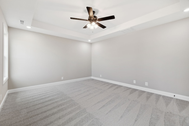 unfurnished room with carpet, a tray ceiling, and ceiling fan