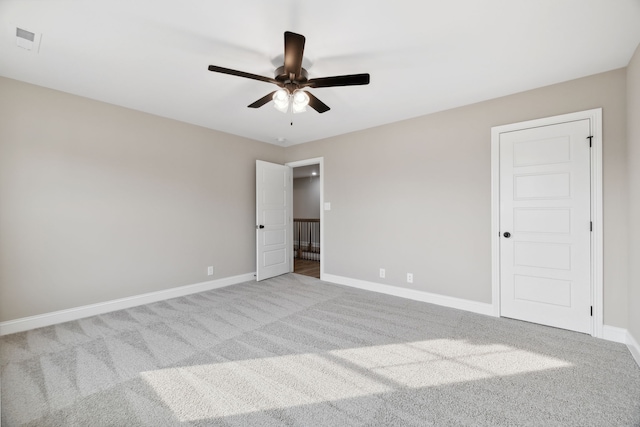 carpeted spare room featuring ceiling fan