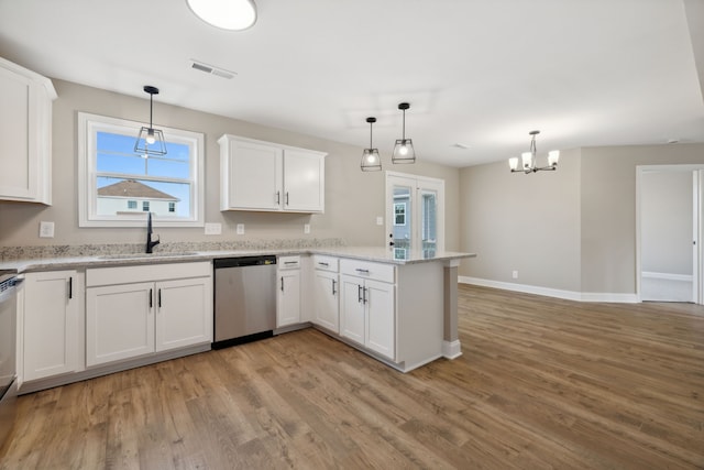 kitchen featuring hanging light fixtures, white cabinets, and stainless steel dishwasher