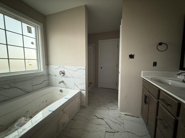 bathroom with a tub, vanity, and tile walls