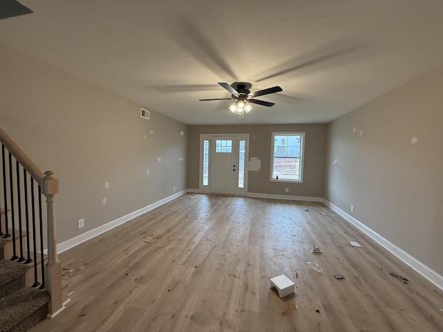 foyer with ceiling fan, a textured ceiling, and light wood-type flooring