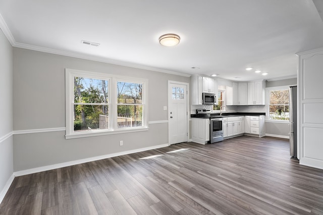 kitchen with appliances with stainless steel finishes, white cabinetry, sink, and dark wood-type flooring