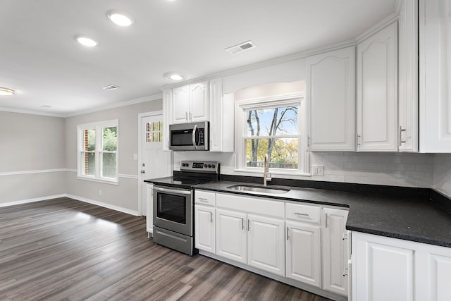 kitchen featuring dark hardwood / wood-style flooring, white cabinetry, sink, crown molding, and stainless steel appliances