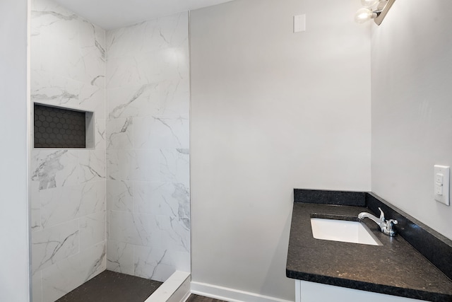 bathroom featuring vanity and tiled shower