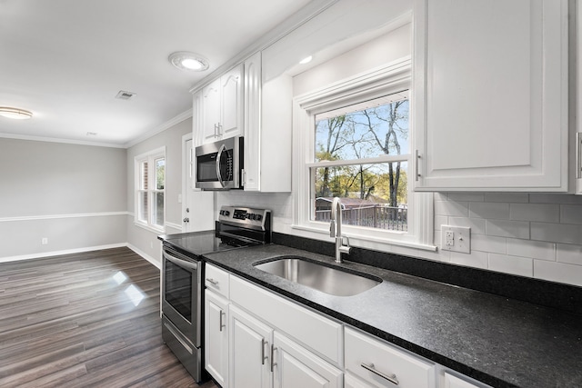 kitchen featuring decorative backsplash, dark wood-type flooring, stainless steel appliances, sink, and white cabinets