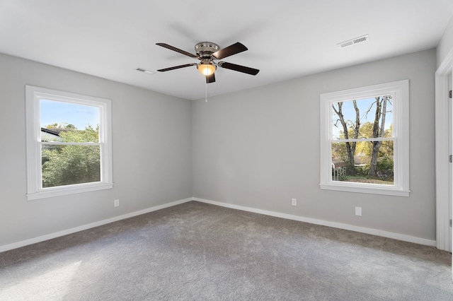 empty room featuring ceiling fan, carpet flooring, and plenty of natural light