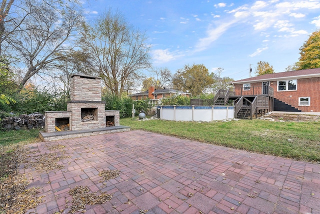 view of patio / terrace with a swimming pool side deck and an outdoor stone fireplace