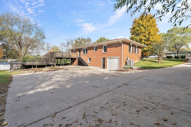 back of house featuring a wooden deck, a garage, and cooling unit