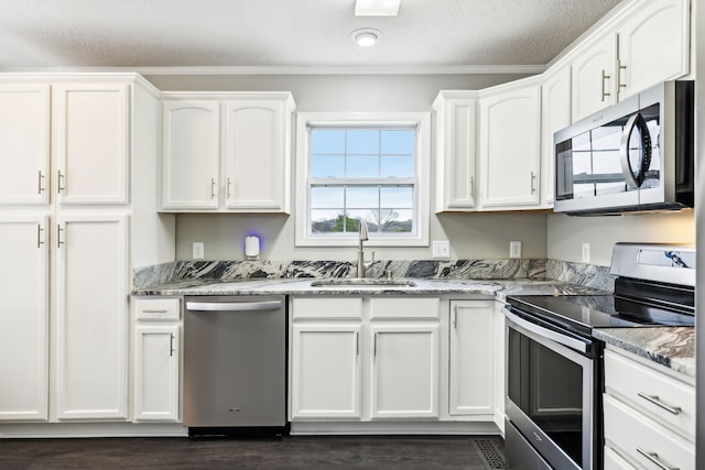 kitchen with white cabinets, sink, a textured ceiling, light stone countertops, and stainless steel appliances