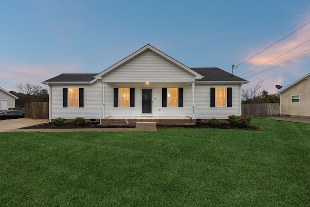 ranch-style home with covered porch and a yard