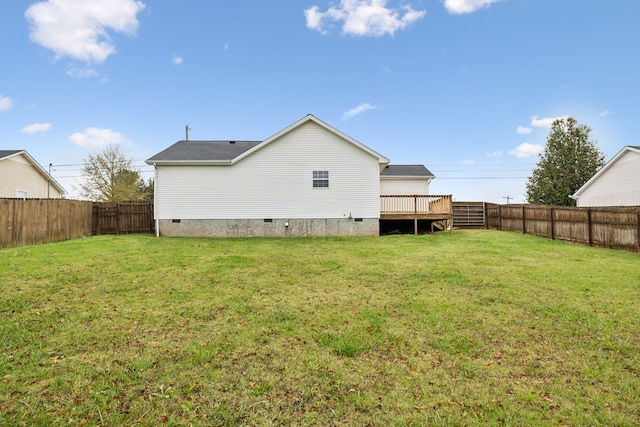 rear view of house with a lawn and a wooden deck