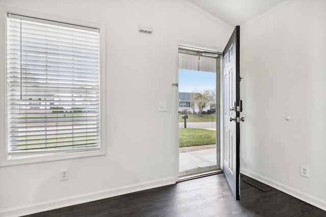 entryway featuring vaulted ceiling, ornamental molding, dark hardwood / wood-style flooring, and plenty of natural light