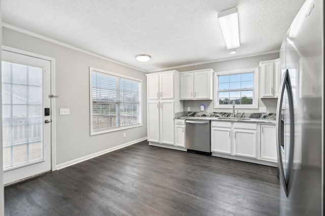 kitchen with white cabinets, appliances with stainless steel finishes, a healthy amount of sunlight, and sink