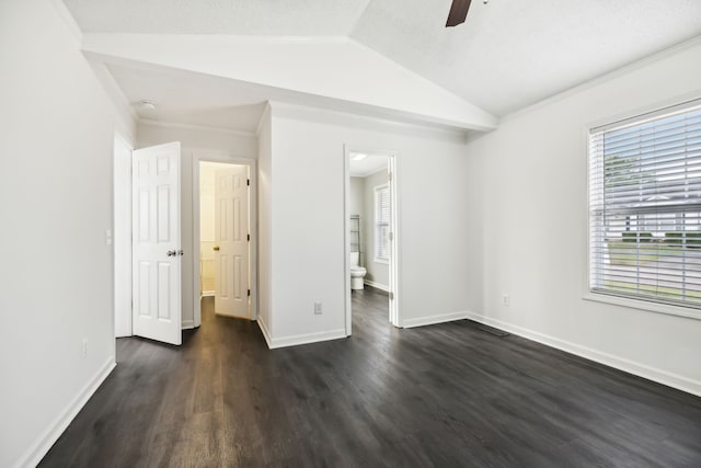 unfurnished bedroom featuring ensuite bath, ceiling fan, dark wood-type flooring, lofted ceiling, and ornamental molding