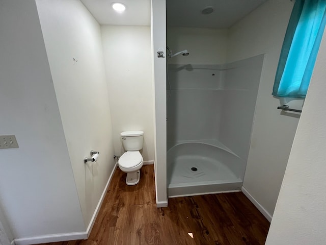 bathroom with toilet, a shower, and hardwood / wood-style floors