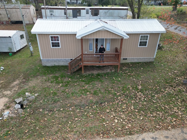 back of house with a storage shed