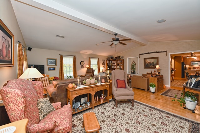 living room with vaulted ceiling with beams, hardwood / wood-style flooring, and ceiling fan