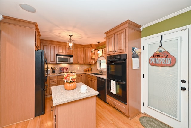 kitchen with light hardwood / wood-style flooring, decorative light fixtures, a center island, and black appliances