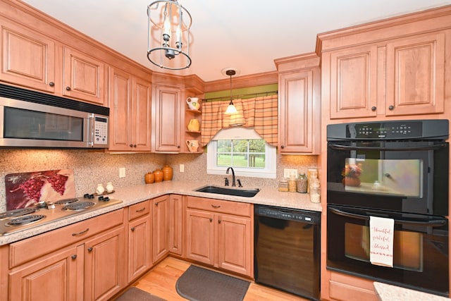 kitchen featuring light hardwood / wood-style floors, black appliances, sink, and hanging light fixtures