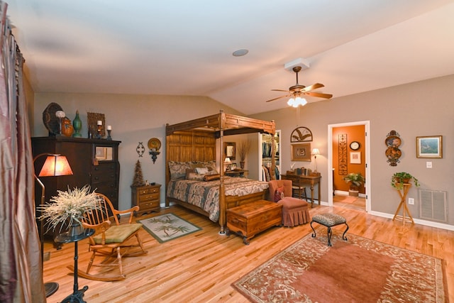 bedroom featuring ceiling fan, hardwood / wood-style flooring, vaulted ceiling, and ensuite bathroom