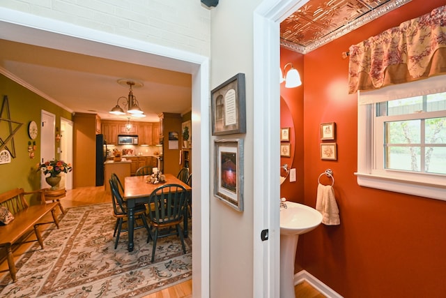 dining area with ornamental molding and light wood-type flooring