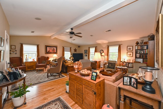 living room featuring light hardwood / wood-style floors, vaulted ceiling with beams, and ceiling fan